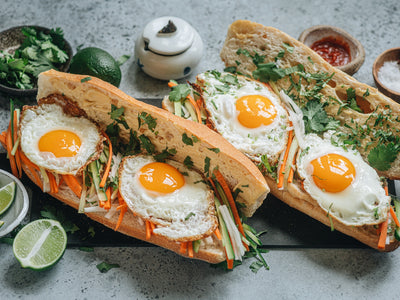 An easy Vietnamese street food recipe for egg banh mi sandwiches made with a crispy baguette, colorful pickled vegetables, fresh herbs, and sunny fried eggs. | peteandgerrys.com