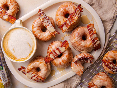 A homemade recipe for yeasted fried donuts glazed with maple icing and topped with crispy bacon. | peteandgerrys.com