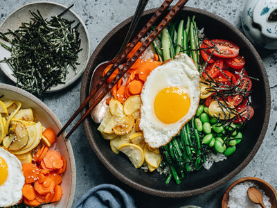 A vegetarian take on bibimbap, a Korean rice recipe, made with summer vegetables and featuring a fried organic egg on top. | peteandgerrys.com
